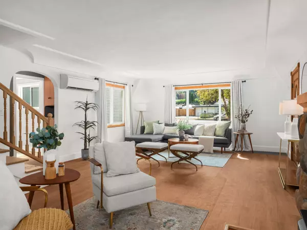 Bright living room with updated LVP flooring and cozy Tudor character – Gatz Home Group.