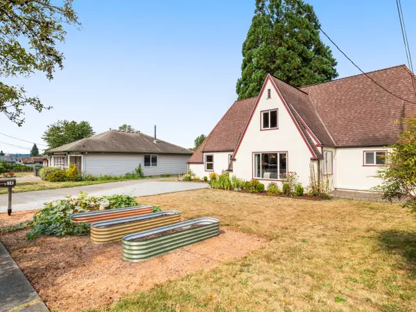 Charming Tudor-style home in Arlington WA with brick accents, steep gables, and mature landscaping – listed by Gatz Home Group.