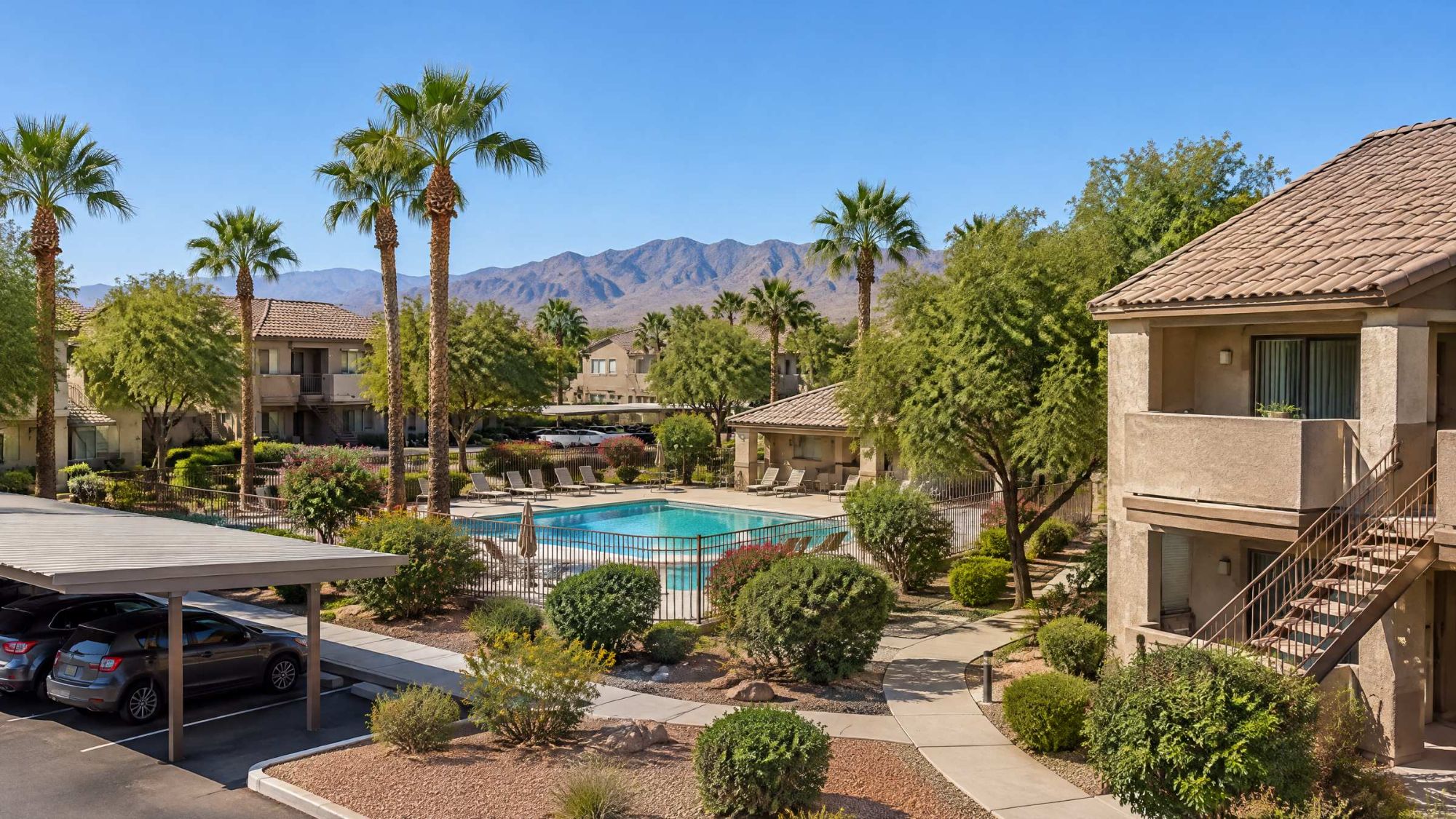 Illustration of a two story stucco condo complex with a pool, palm trees and covered parking.