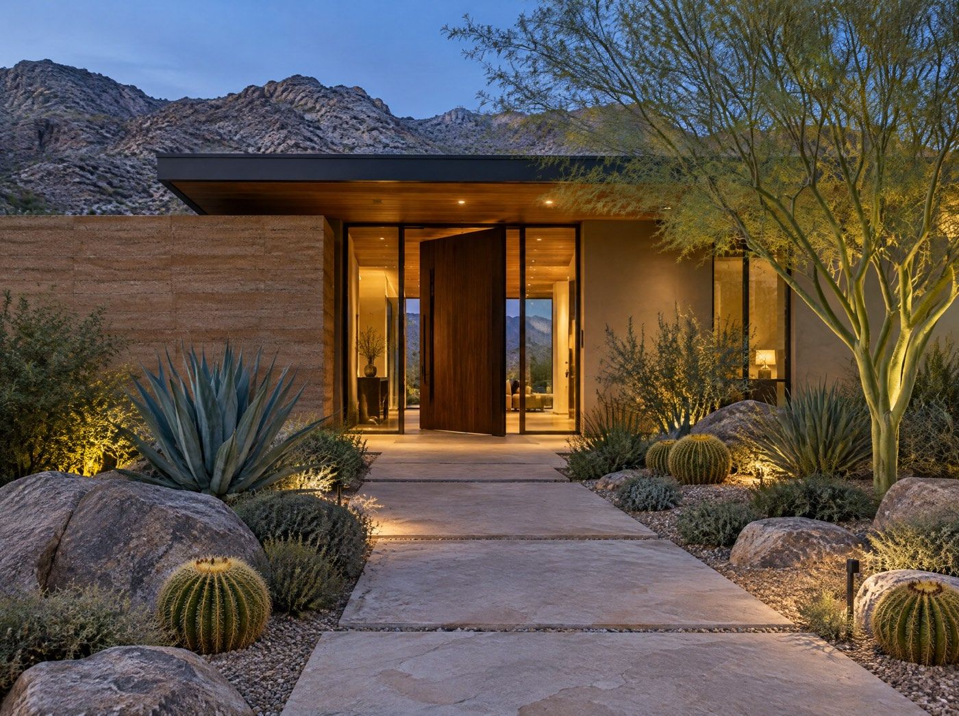 Illustration of a modern desert home entry with a stone path, boulders and cactus at dusk.