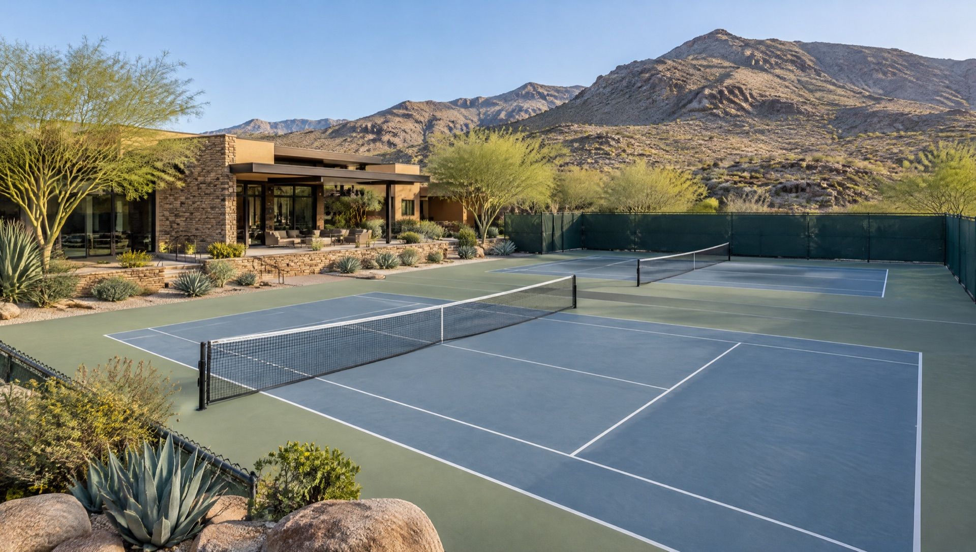 Illustration of tennis courts beside a stone and glass club building, with desert foothills behind.