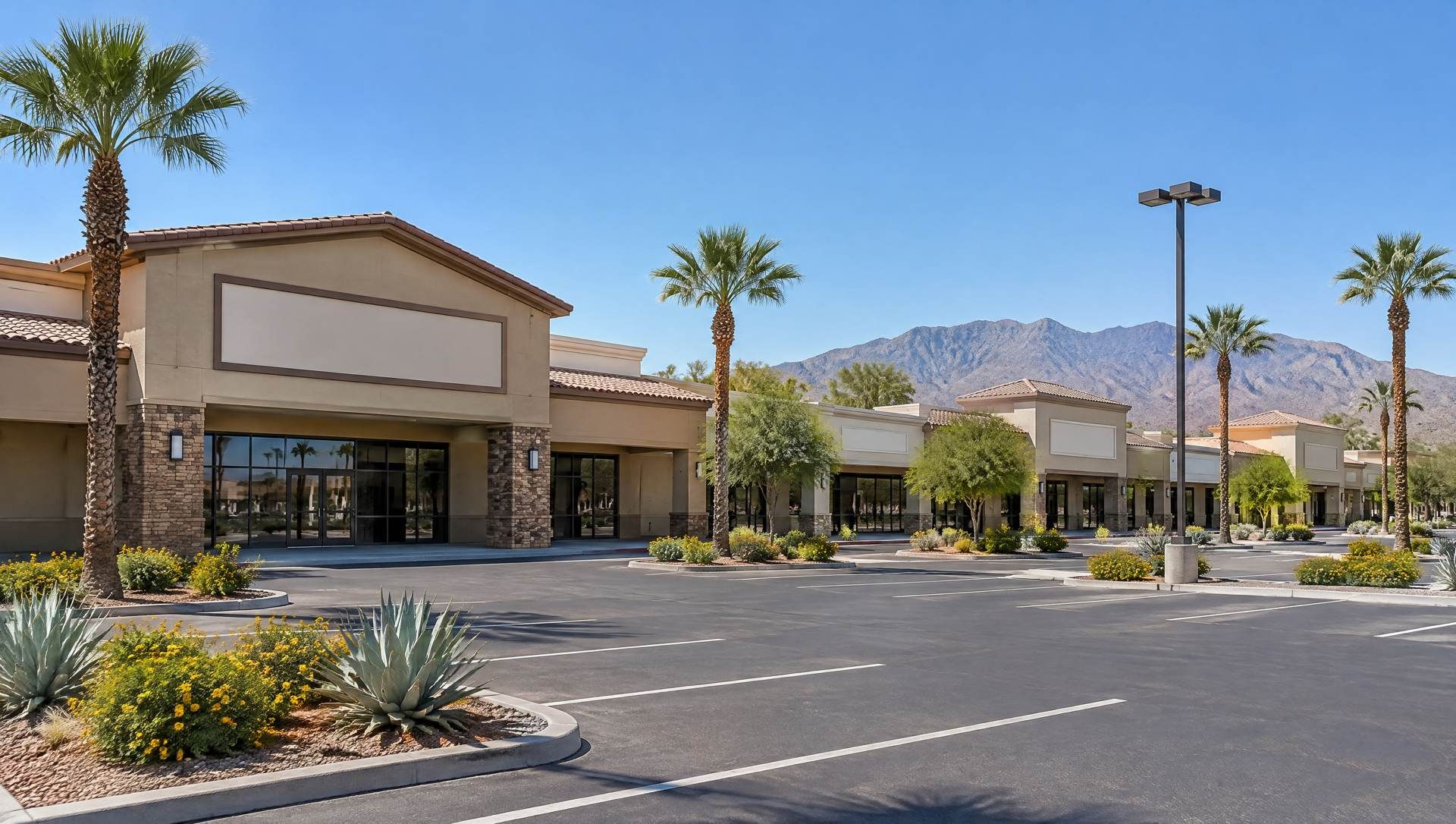 Illustration of a stucco shopping center with palm trees and mountains behind.