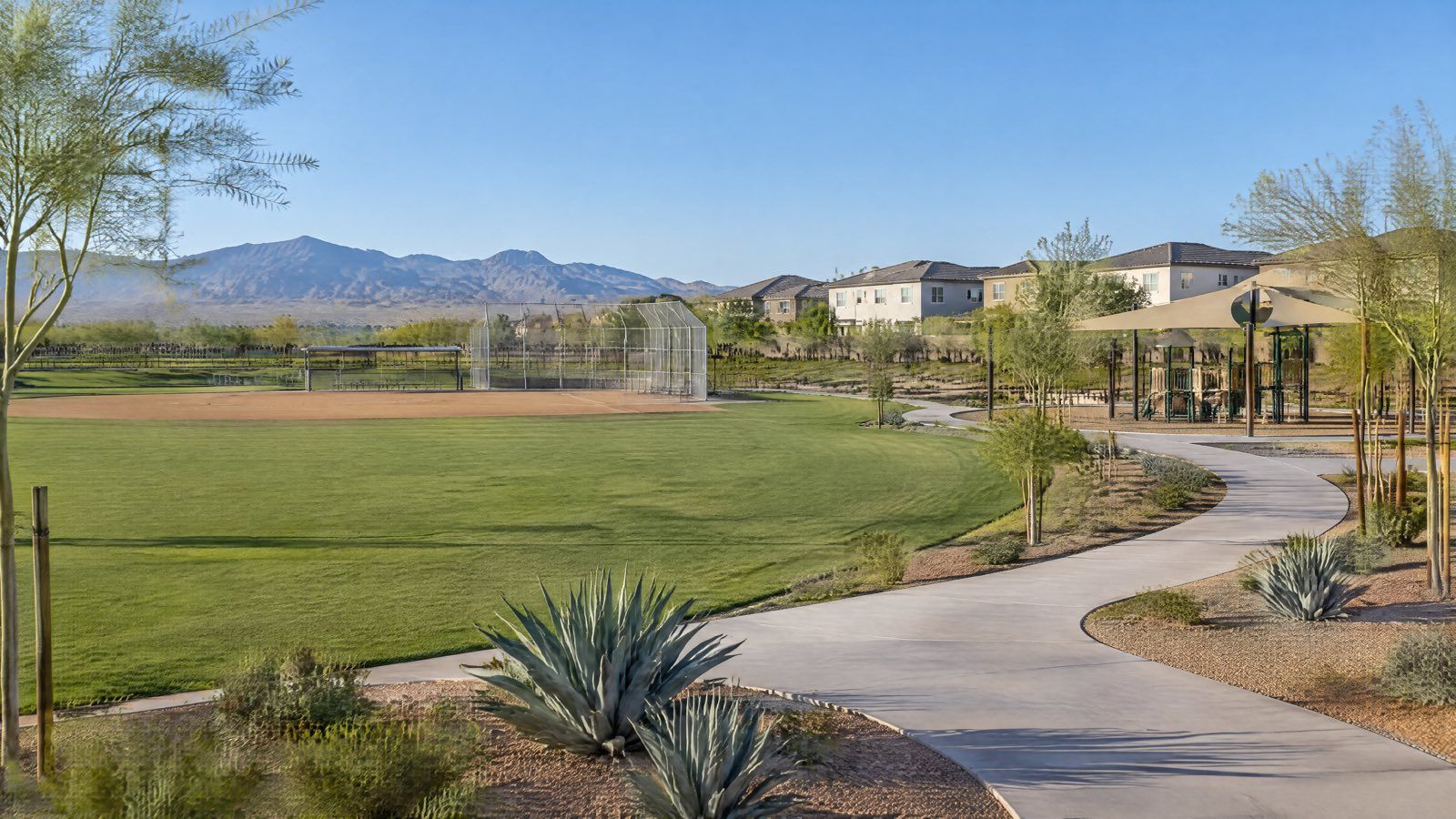 Illustration of a park lawn, ball field and playground with homes and grey mountains behind.