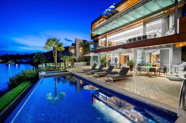 Luxury waterfront estate in Dundarave, West Vancouver - infinity pool with ocean views at dusk, featuring lounge chairs, fire pit, and private beach access