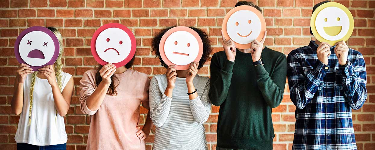 People holding different emotion masks