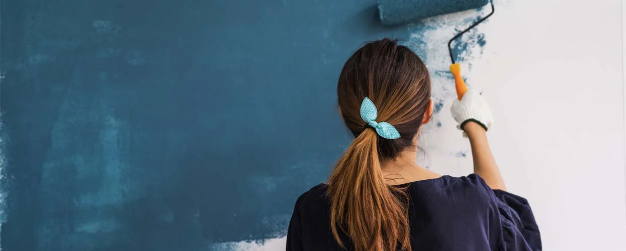 A woman painting a wall