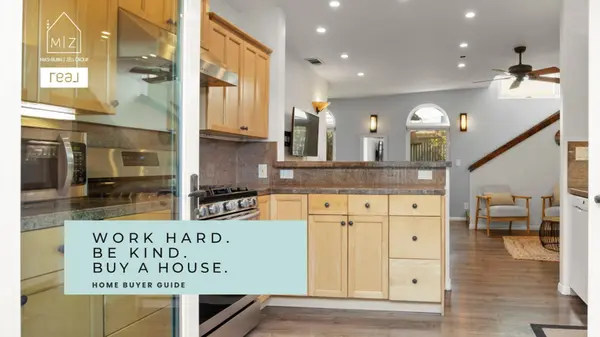 Kitchen with wood cabinets, stainless appliances, and view into living area