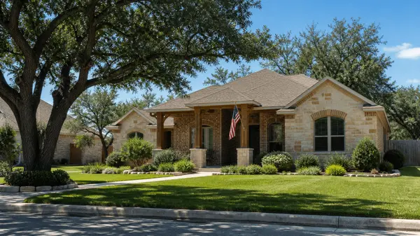 Central Texas brick and stone home with an American flag on the front porch