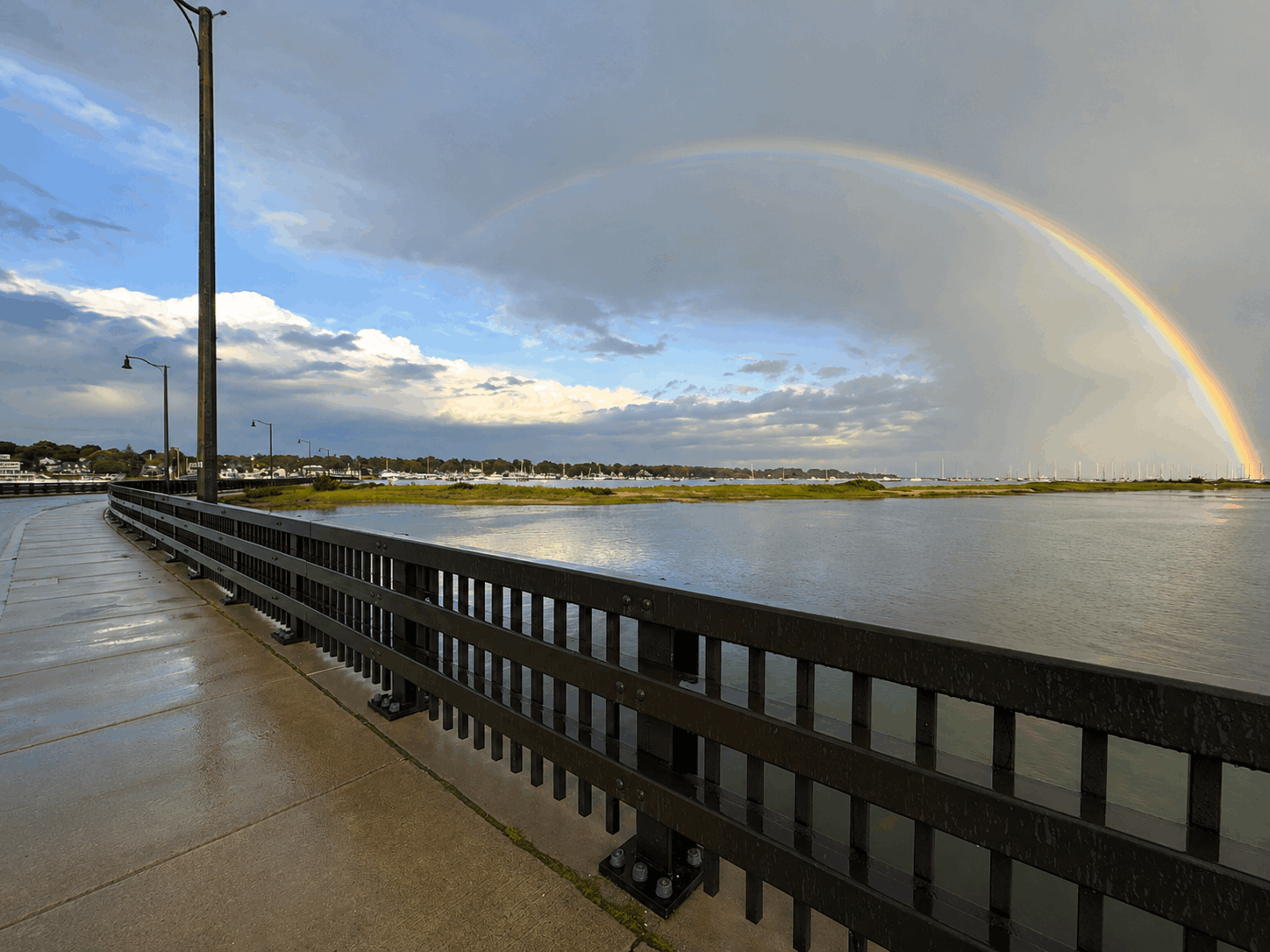 Full rainbow arc over Padanaram Harbor from the causeway walkway