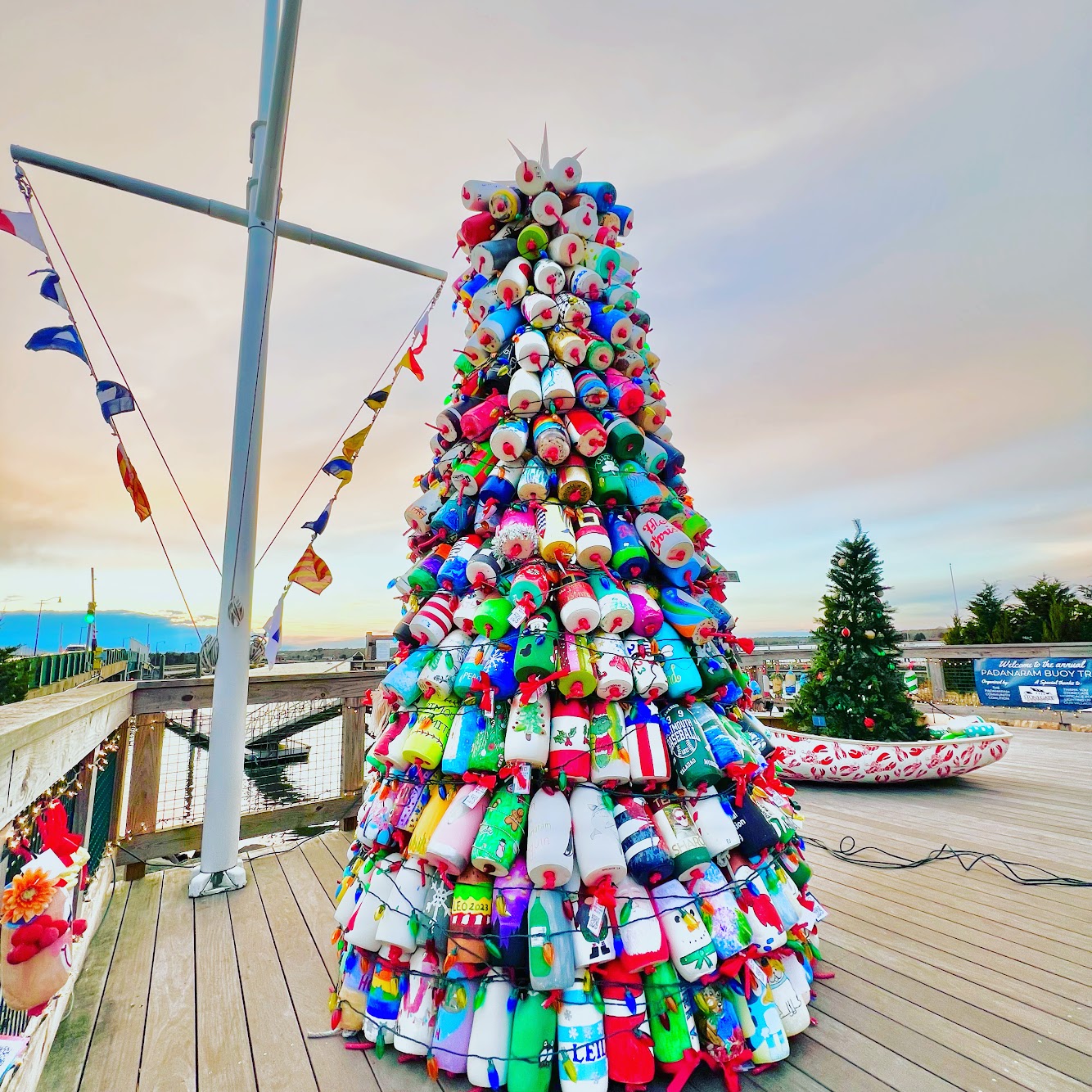 The Padanaram Buoy Tree, a holiday tree made of painted lobster buoys, on the wharf at dusk in Padanaram Village, South Dartmouth