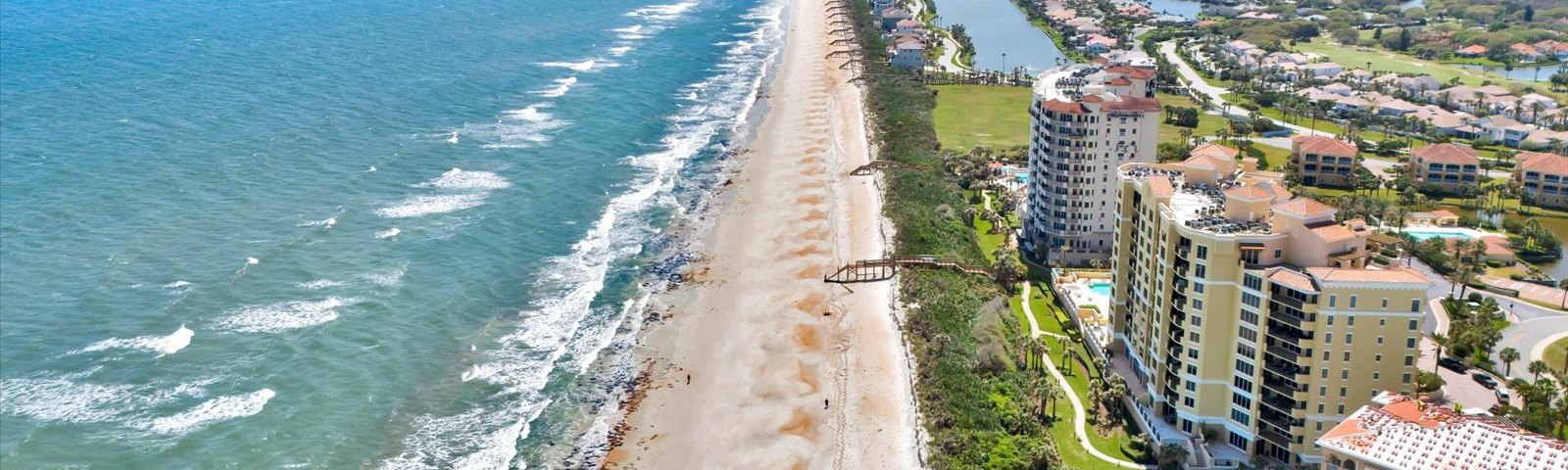 Aerial view of the beach and oceanfront condos at Hammock Dunes in Palm Coast FL