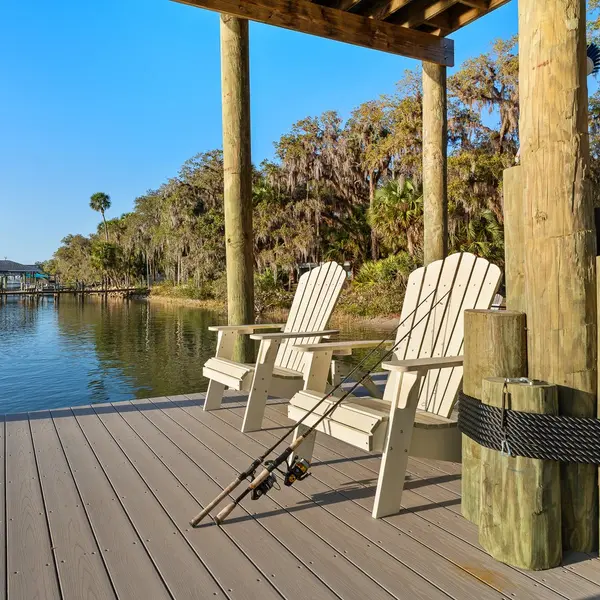 Private dock with Adirondack chairs and fishing rods on the Intracoastal Waterway in the Hammock, Palm Coast FL