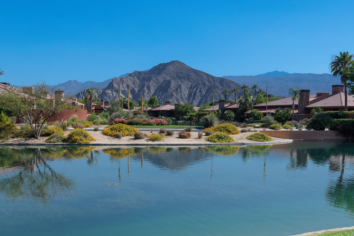 Palmilla residences in La Quinta overlooking expansive water features with desert landscaping and Santa Rosa Mountain views