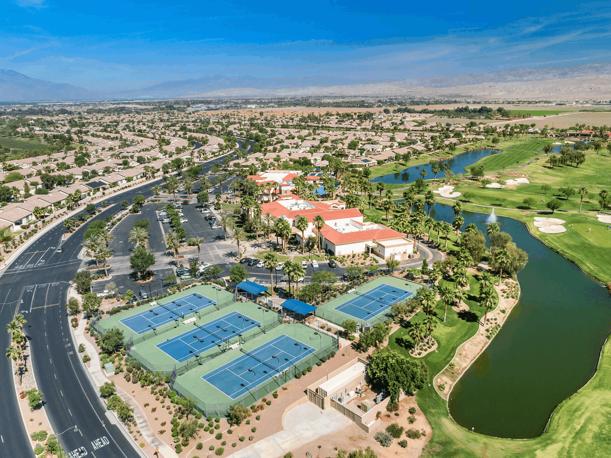 Aerial view of Sun City Shadow Hills clubhouse, recreation courts, golf course and residential neighborhoods in Indio