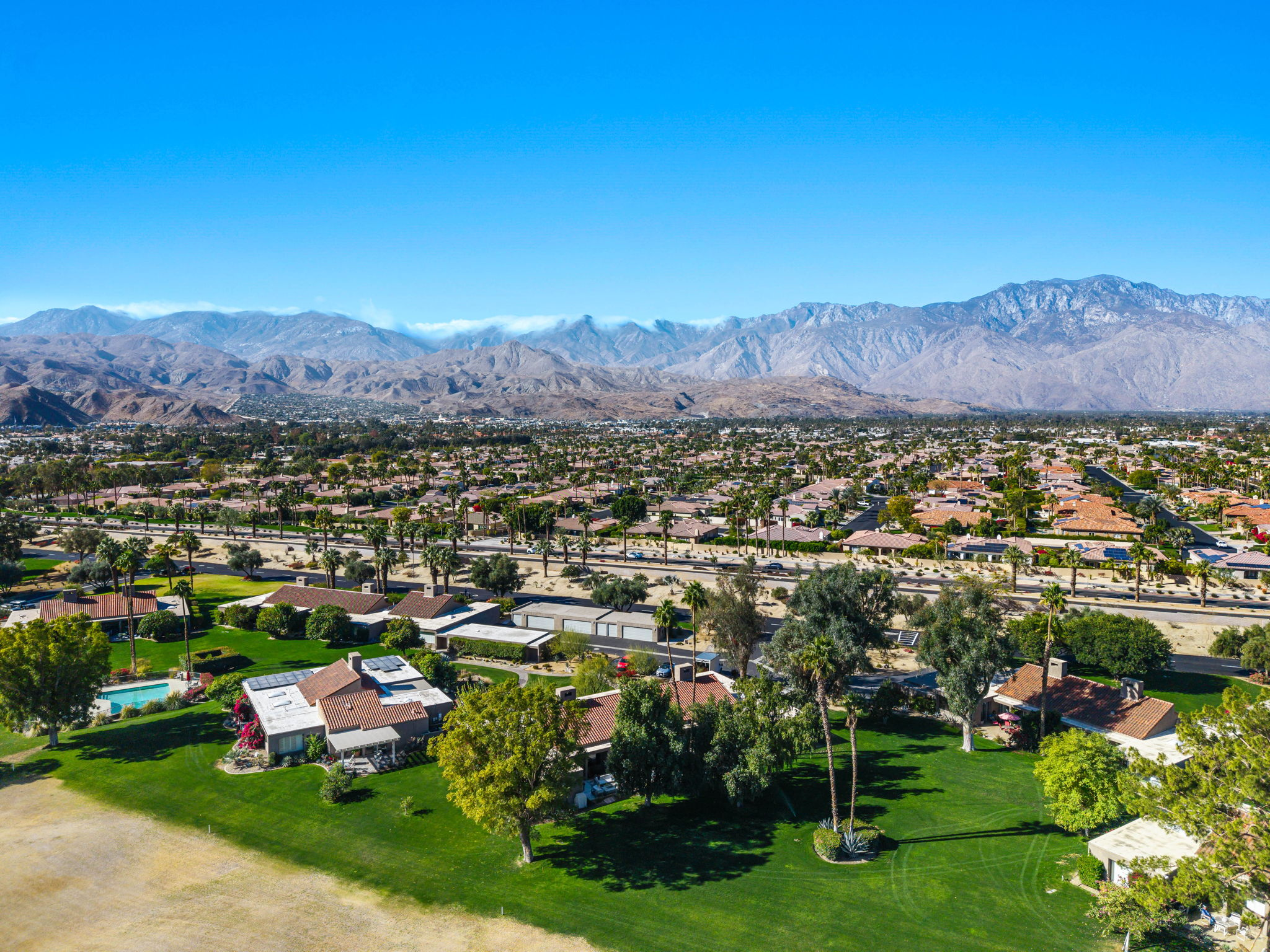 Aerial view of homes at Mission Hills Country Club in Rancho Mirage with golf course landscaping and surrounding mountains