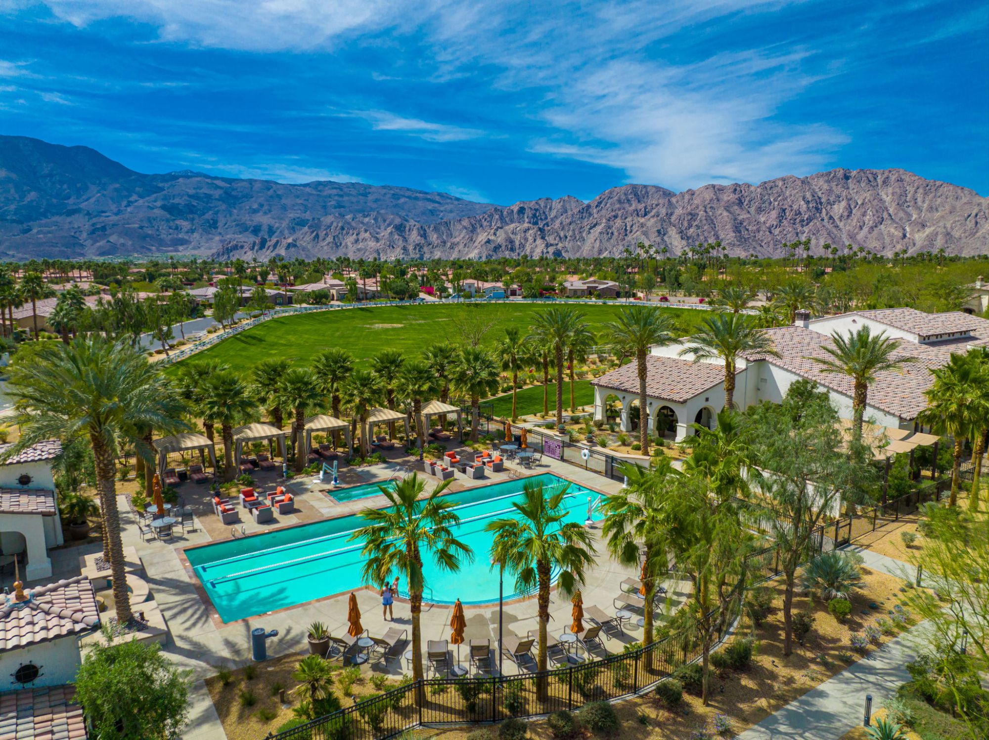 Aerial view of the Griffin Ranch clubhouse, resort-style pool, green space and Santa Rosa Mountains in La Quinta