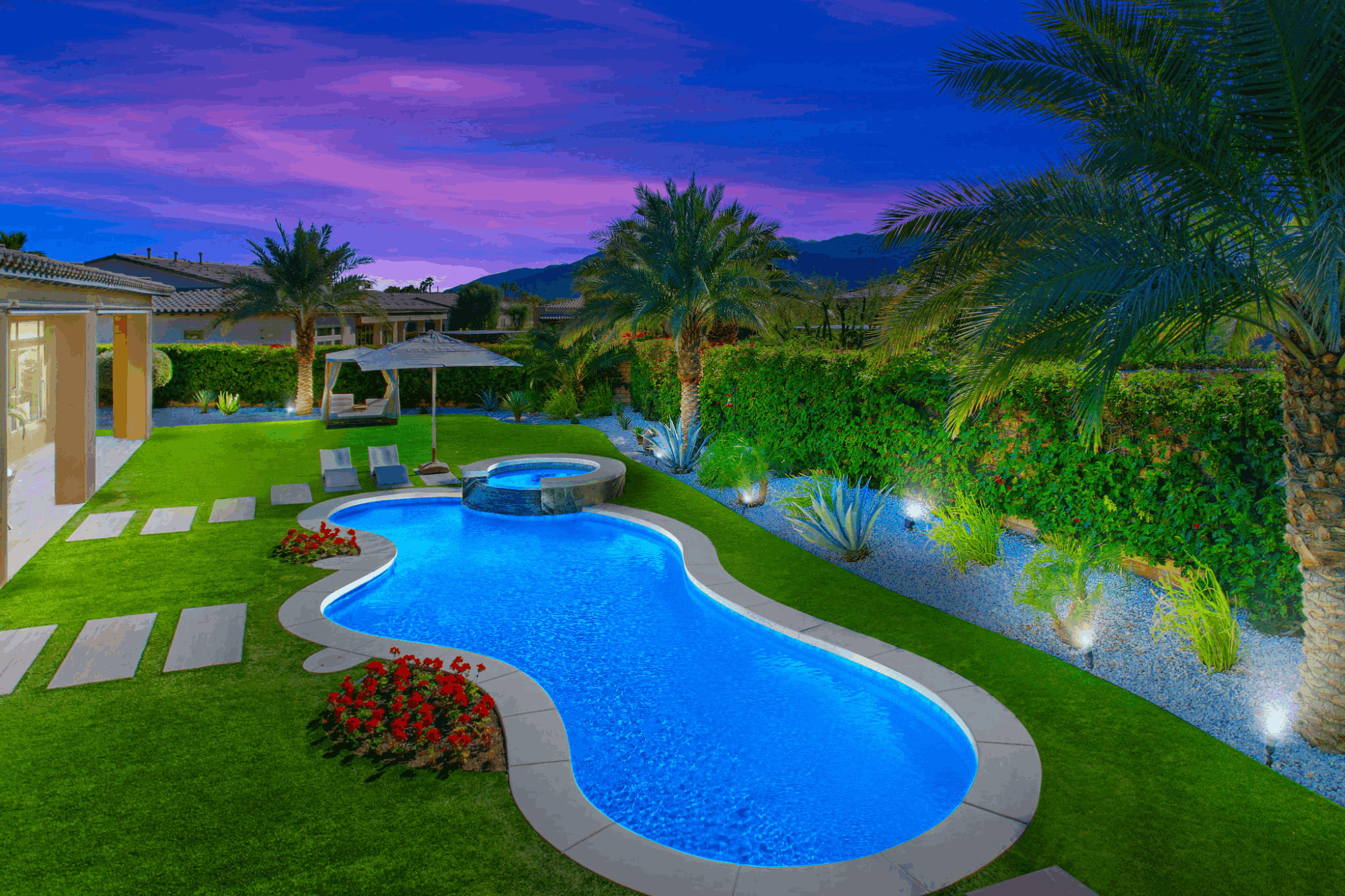 Private swimming pool and spa at a Griffin Ranch residence with palm trees and mountain views at twilight