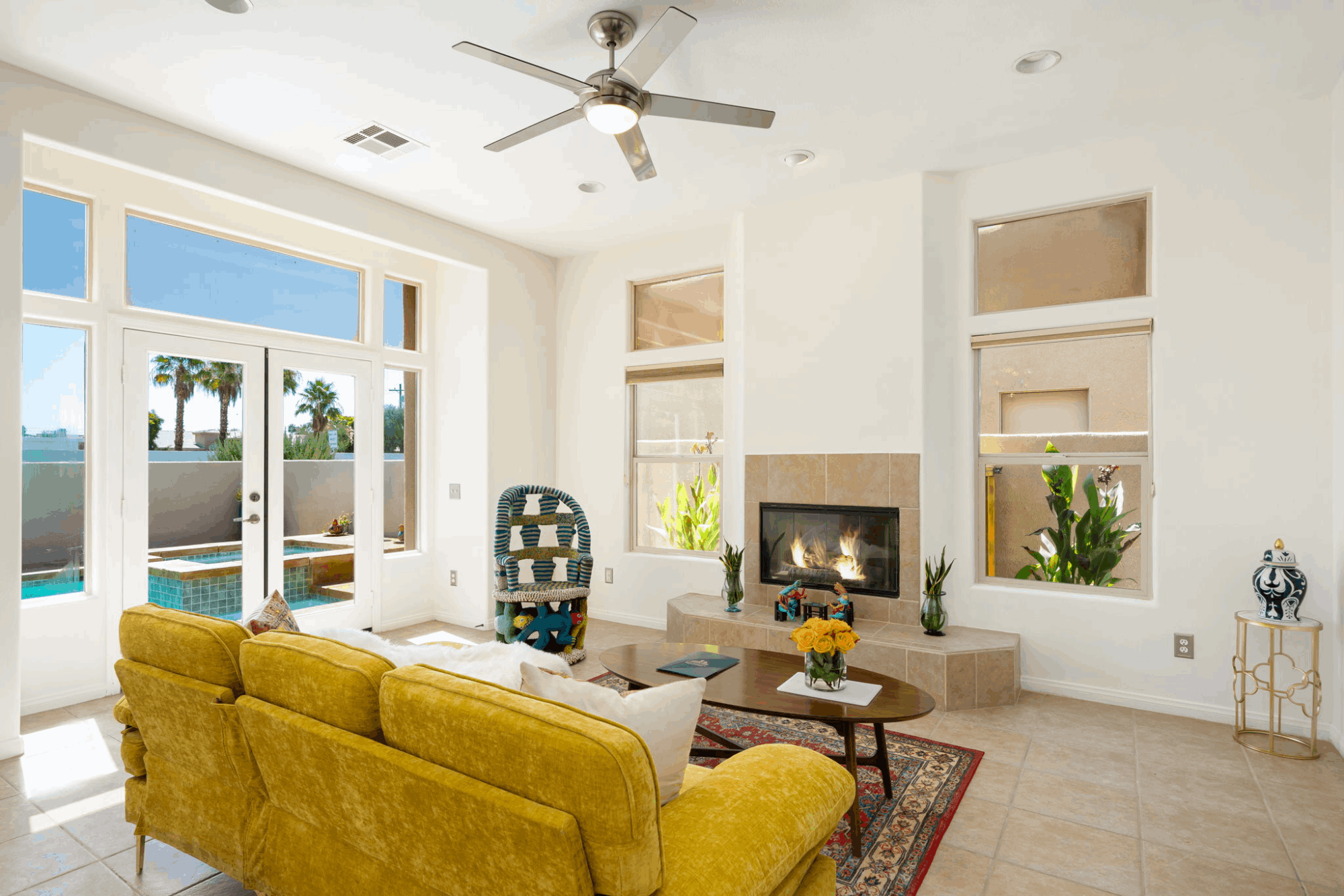 Bright La Quinta Cove home interior with fireplace, high ceilings and doors opening to a private pool
