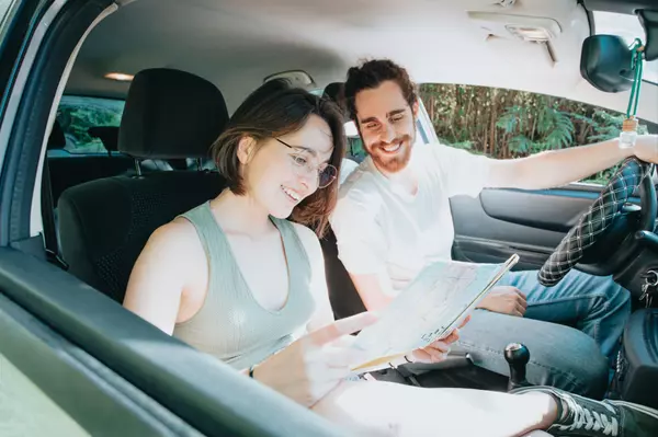 Two People in car looking at map for home location Vision Realty