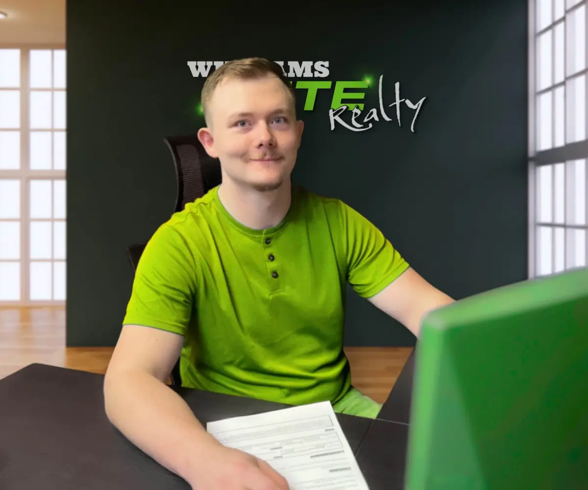 Real estate agent at Williams Elite Realty office in Kentucky assisting homebuyers with paperwork