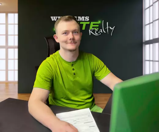Real estate agent at Williams Elite Realty office in Kentucky assisting homebuyers with paperwork