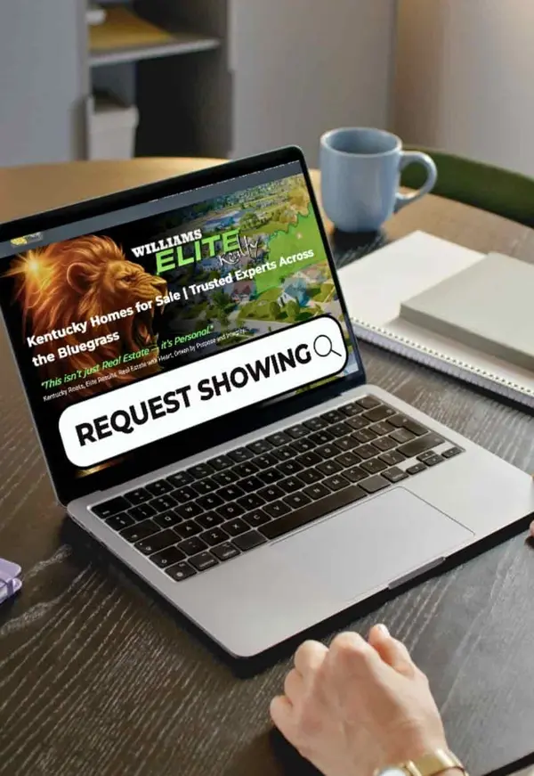Person using a laptop to request a home showing on the Williams Elite Realty website, featuring a modern house for sale and an online form with name and email fields
