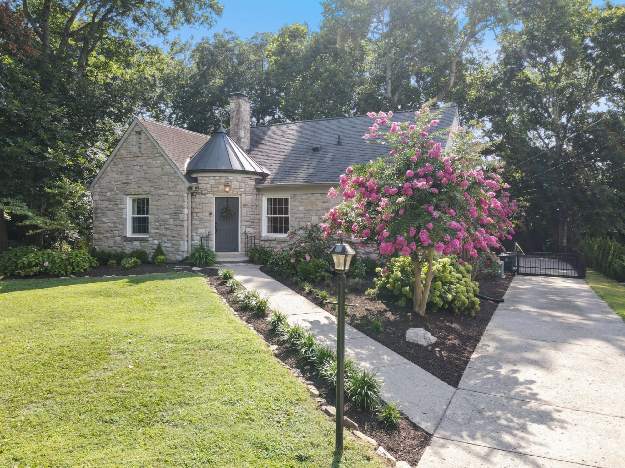 Stone cottage with a flowering tree and front walk