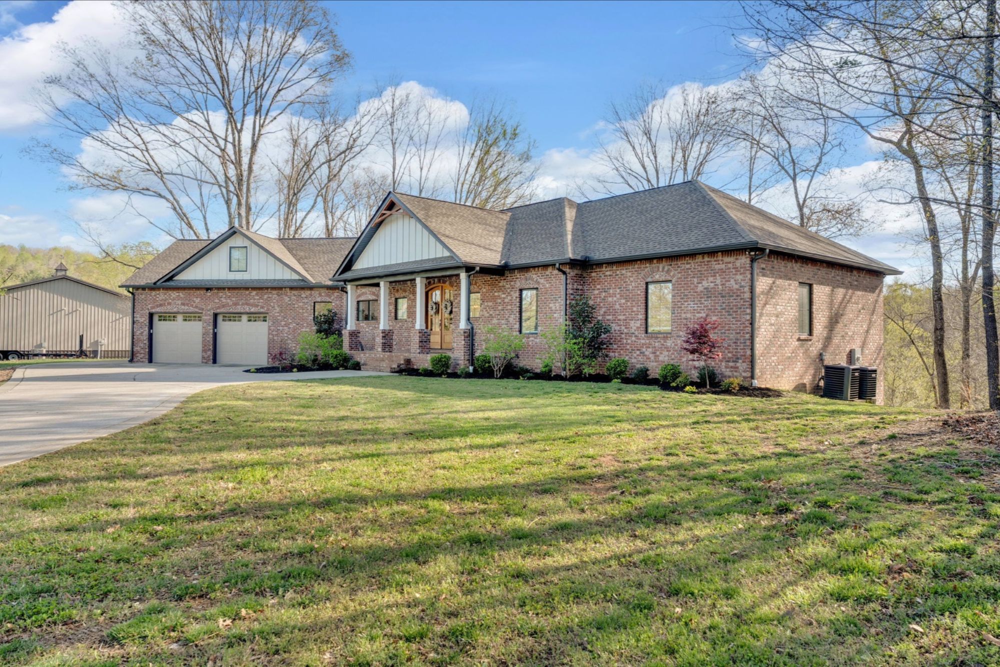 Brick home with a long front lawn under mature trees
