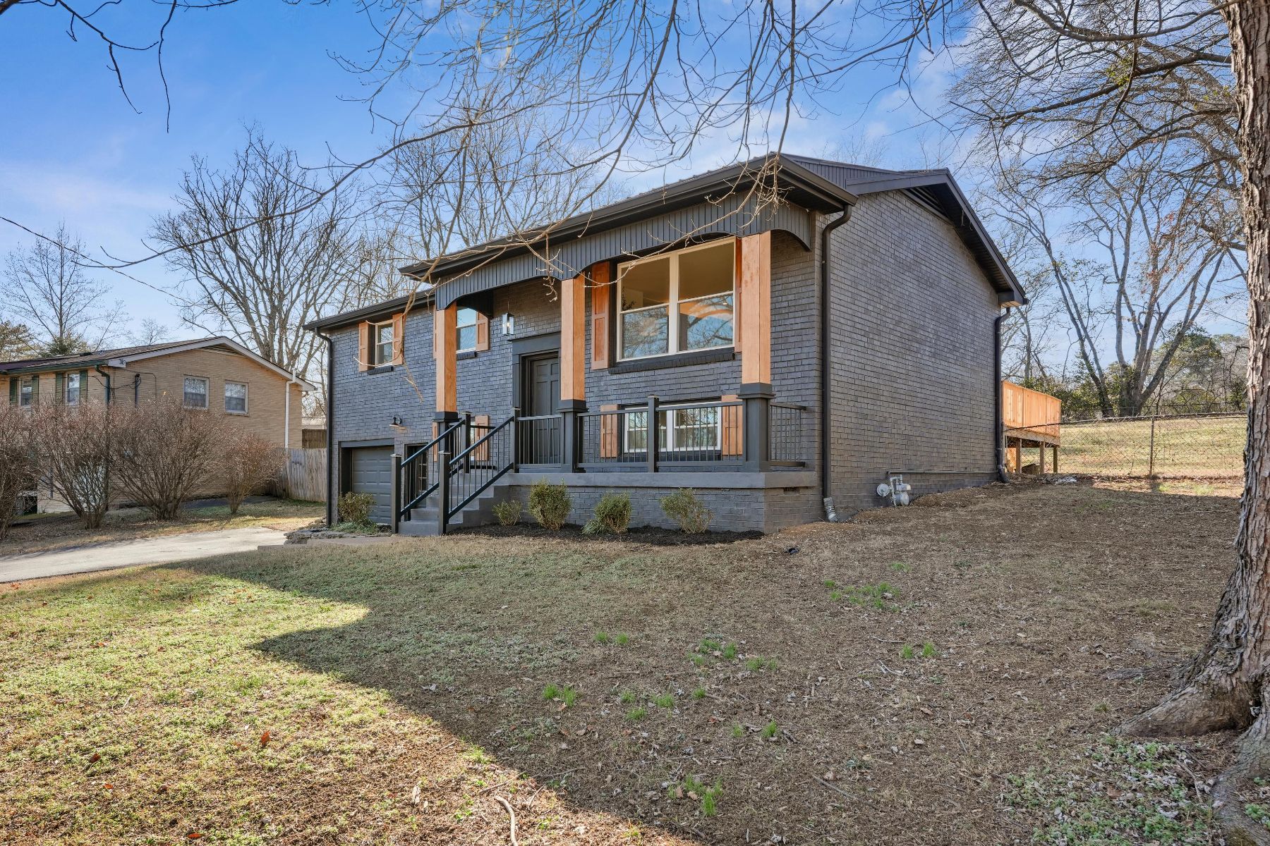 Two-story charcoal home with cedar accents and a front porch