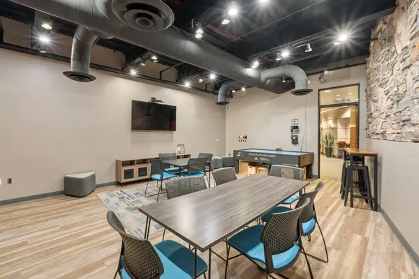 Teen room at Fireside at Norterra with tables, chairs and gaming table. 