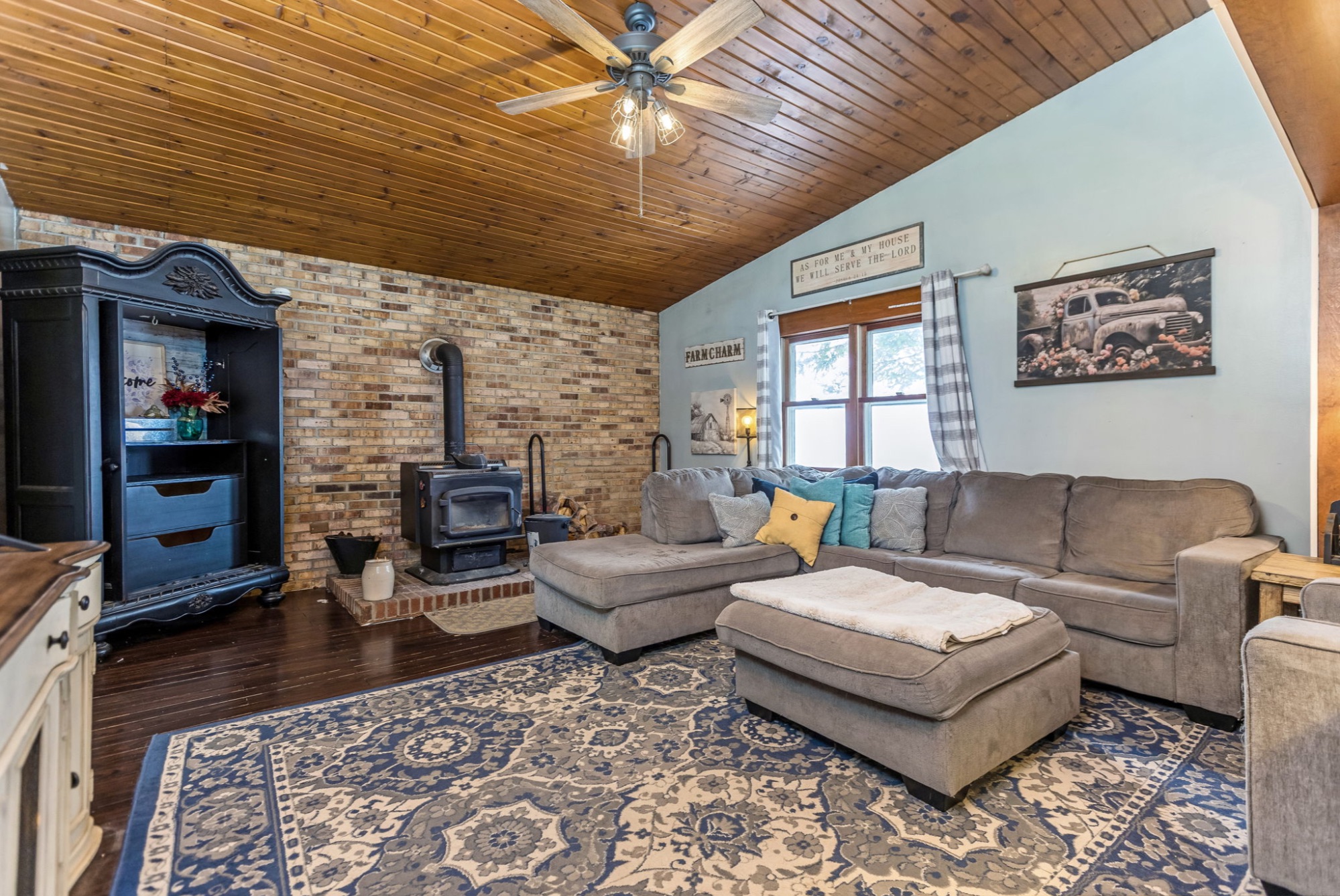 Cozy living area with wood-burning stove and brick hearth in Radnor Ohio farmhouse