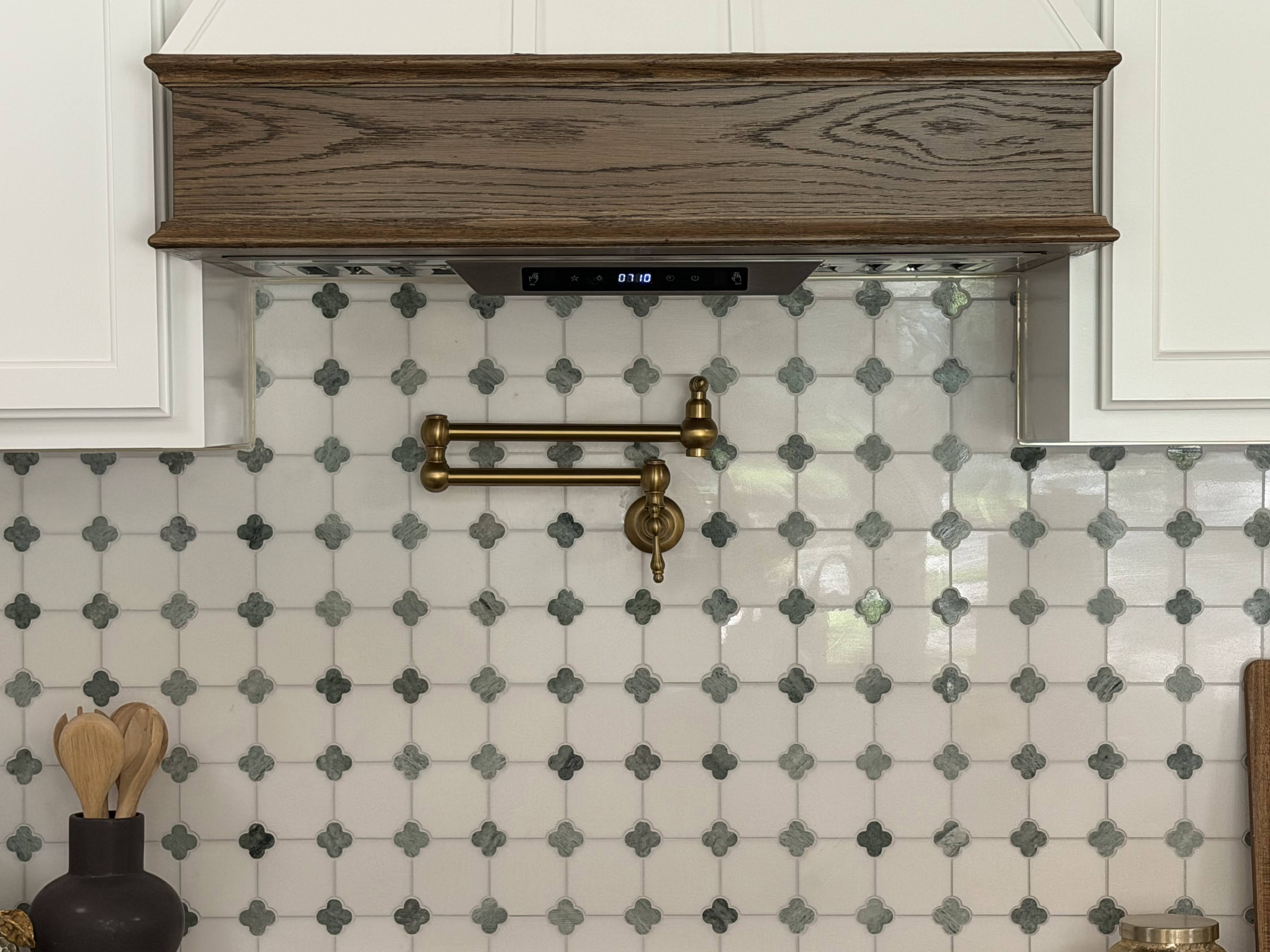 The tile backsplash in the kitchen with the green clover motif embedded.