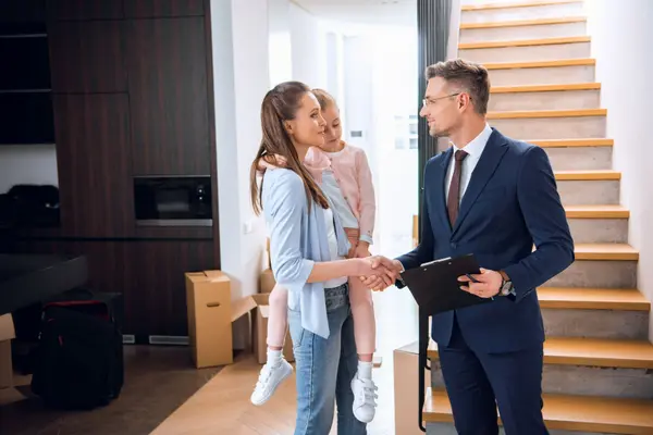 real-estate-agent-meeting-woman-and-child-at-home-2026-03-12-23-56-28-utc