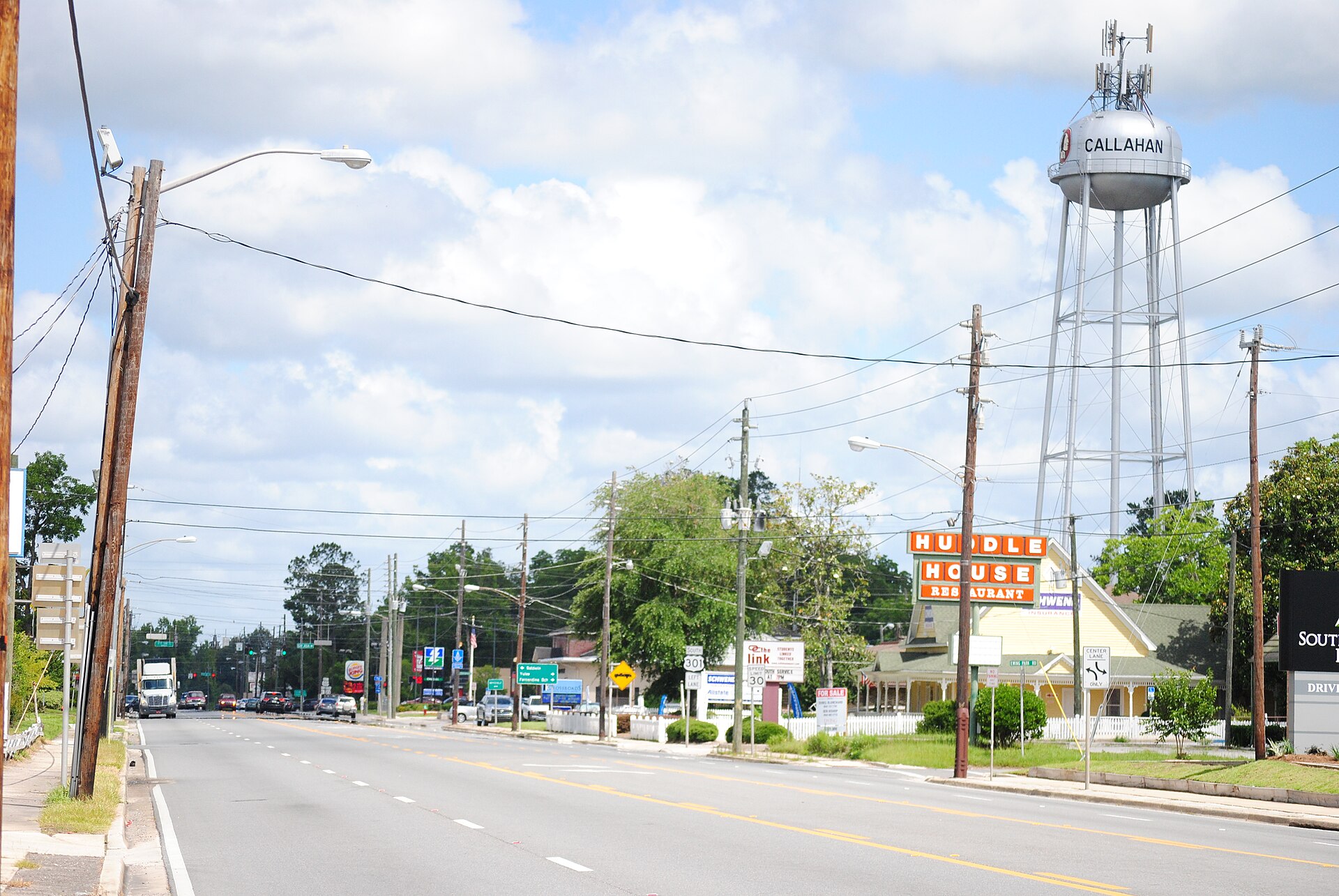 Small-town main street with brick storefronts and shade trees in Callahan, Florida