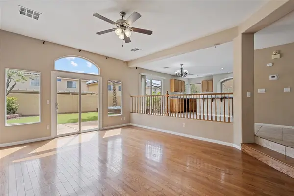 living room with wood floors step down slider and 6 windows bright sun with views to back yard very open