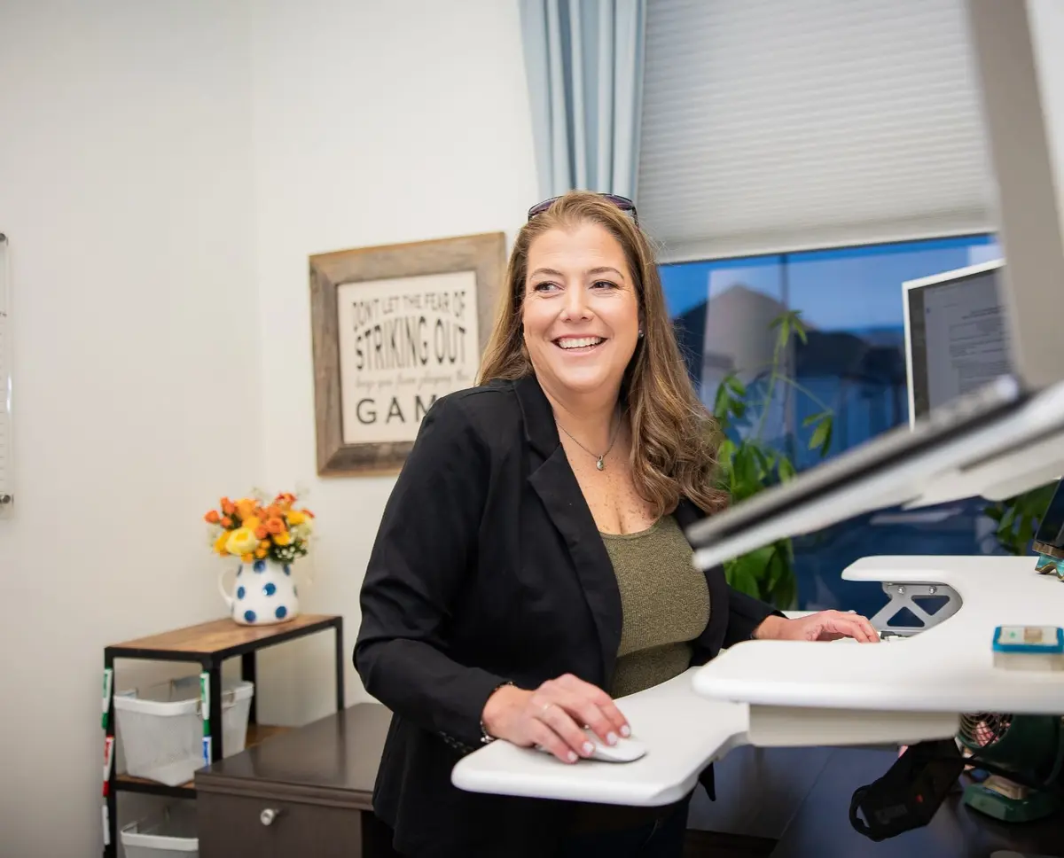Erin O'Brien smiling while working on a computer.