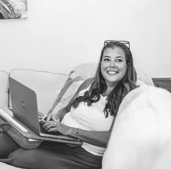 Erin O'Brien smiling while using a laptop computer