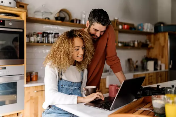 couple-looking-at-laptop-in-kitchen-2024-10-15-00-51-20-utc (1)