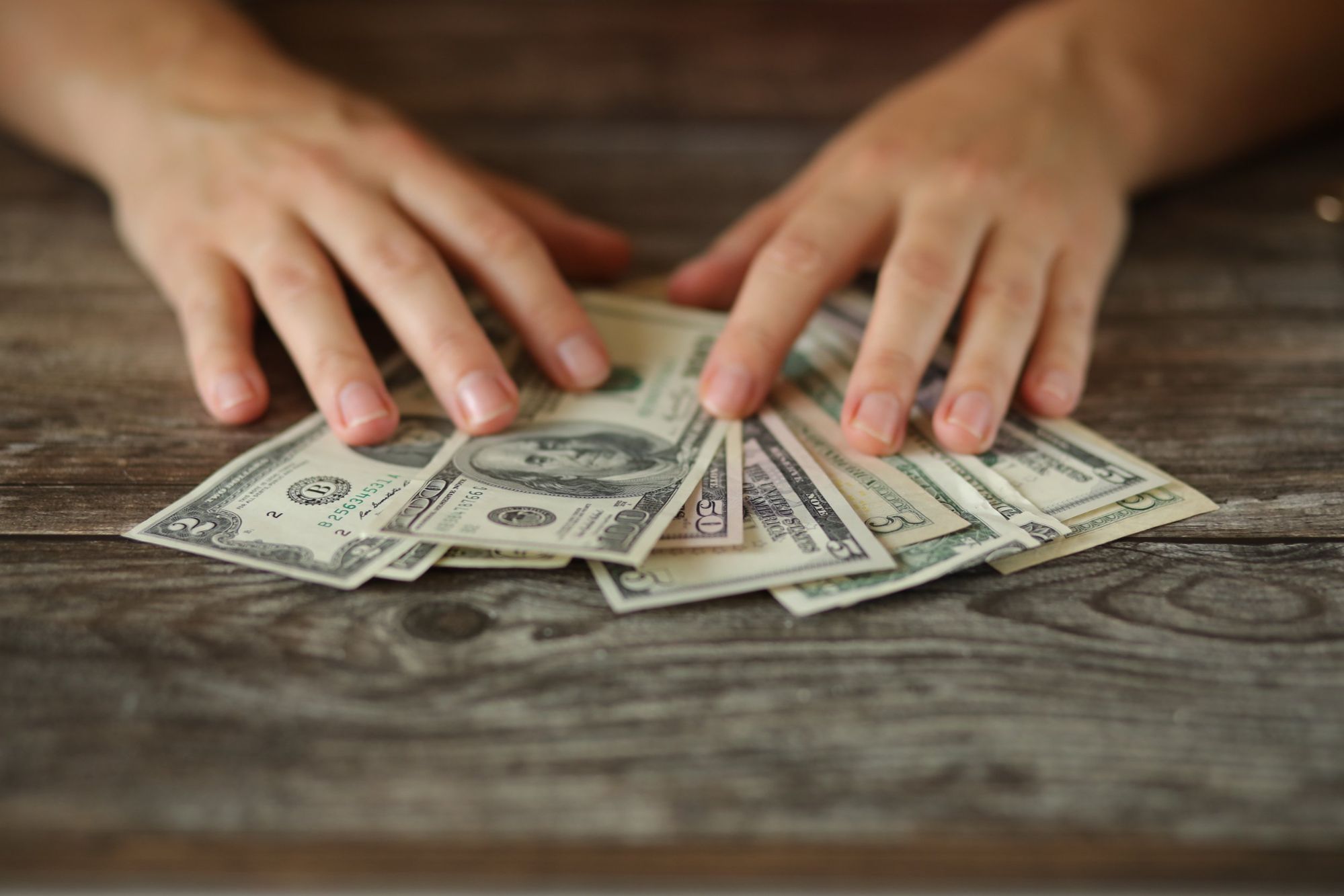 Hands counting money for Escrow Deposit on Orlando Real Estate