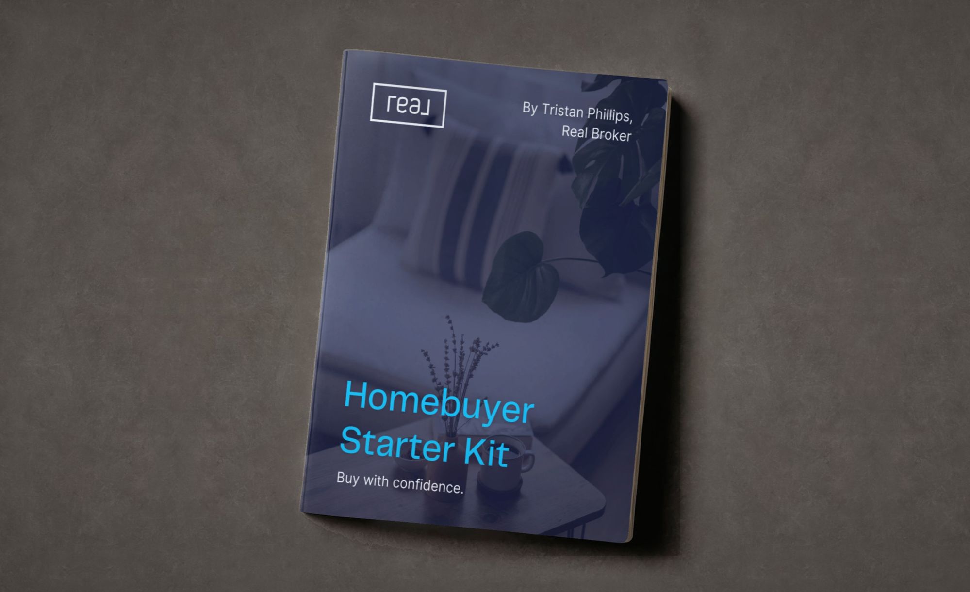 Homebuyer Starter Kit, a buyer's guide by Tristan Phillips of Real Broker, shown as a printed booklet on a concrete surface