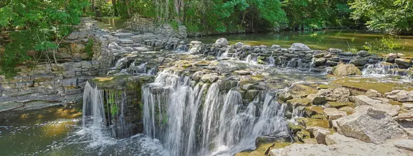 Waterfall over stone ledges at Prairie Creek Park in Richardson, Texas