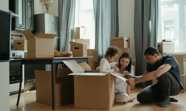 A family unpacking moving boxes in the kitchen of their new home