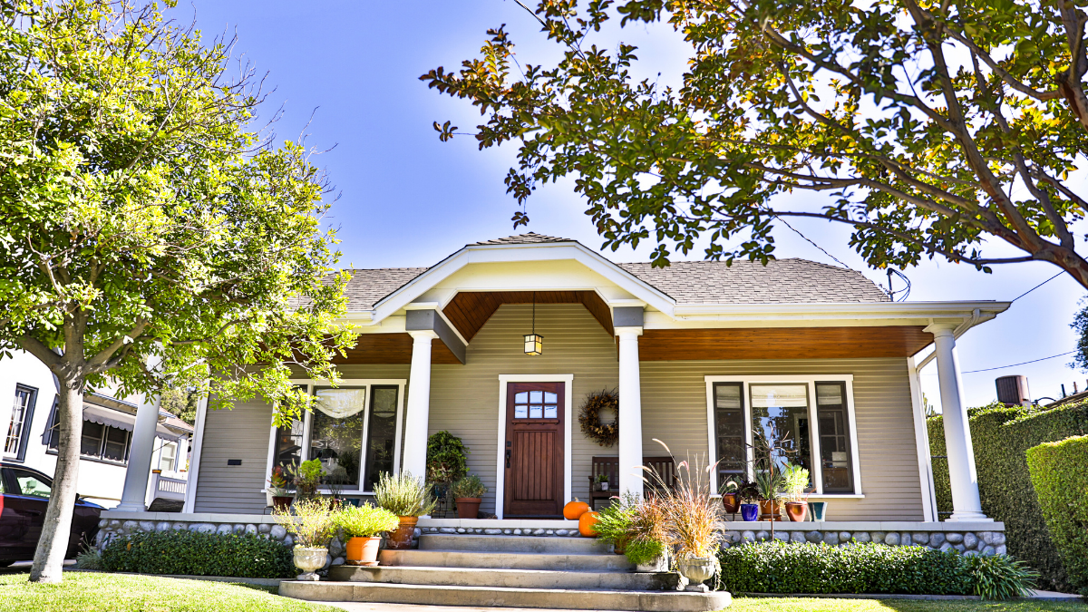 Front view of a detached single-family home with a covered porch and landscaped yard.