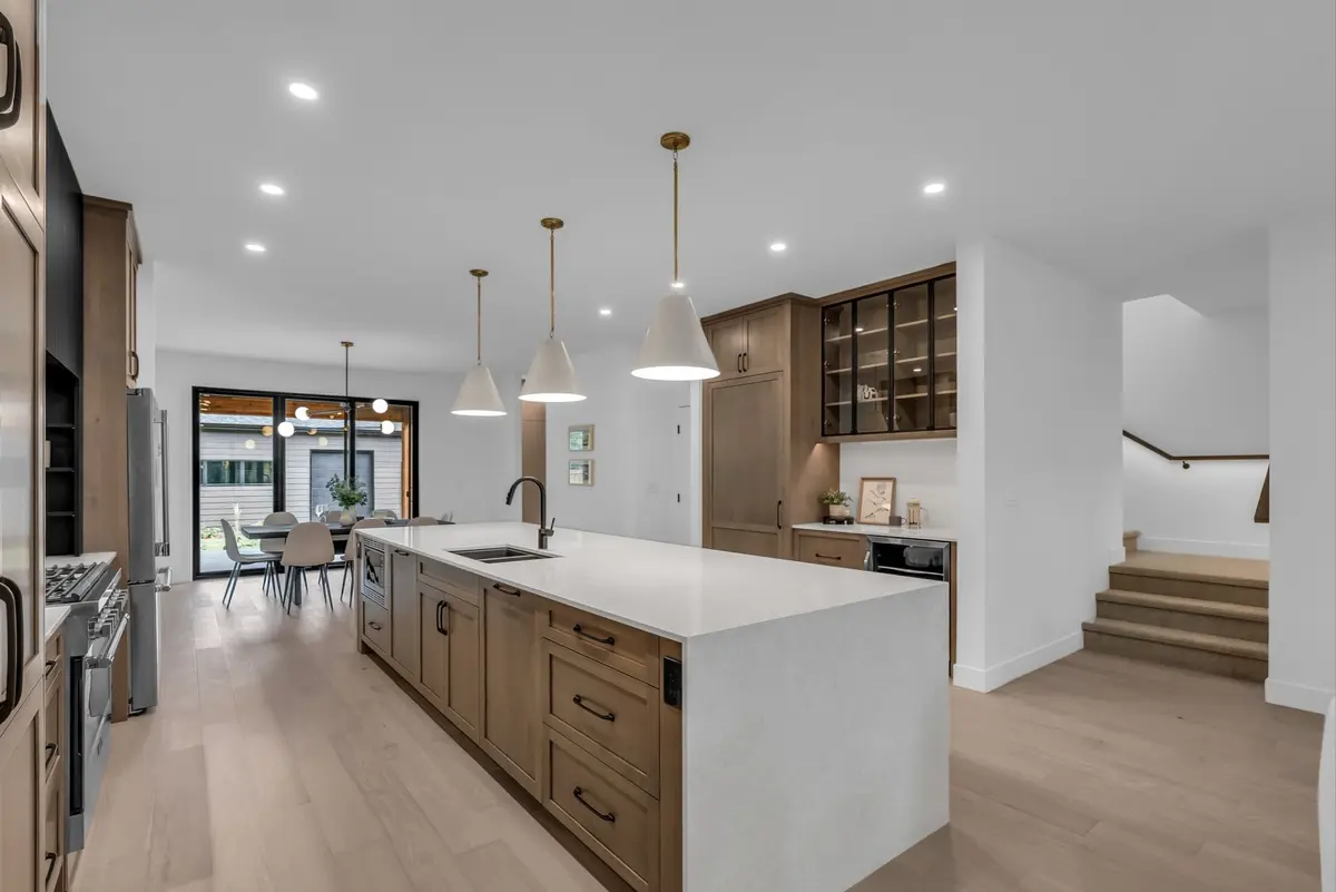 Modern luxury kitchen with custom cabinetry, dedicated drinks area, hidden pantry & hardwood floors,