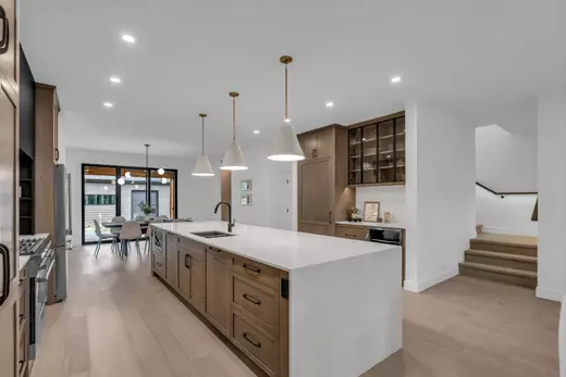 Modern luxury kitchen with custom cabinetry, dedicated drinks area, hidden pantry & hardwood floors,