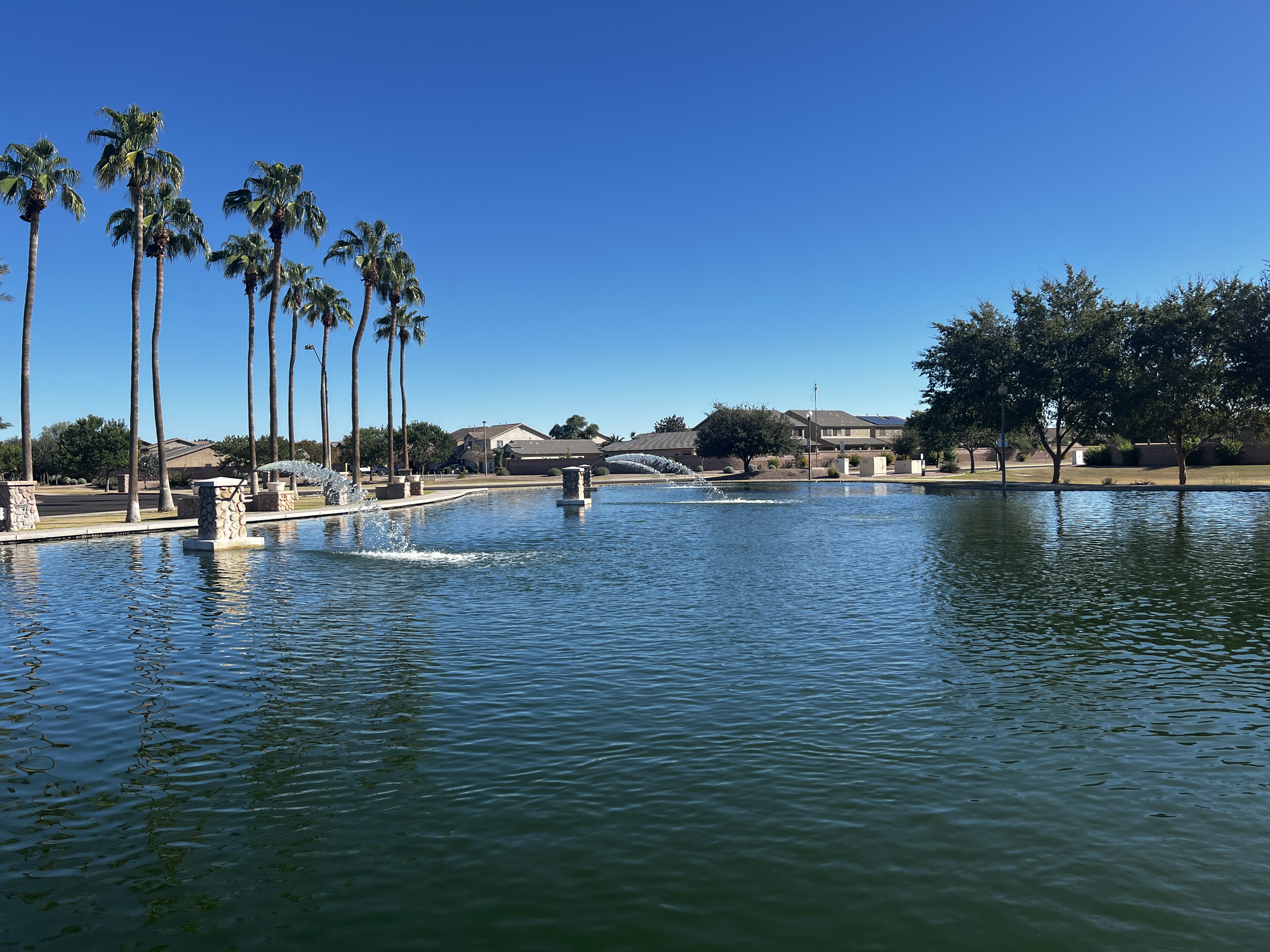 Community lake and walking path in a Maricopa AZ HOA neighborhood