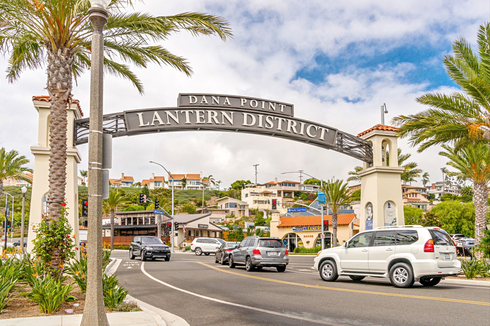 : A well-appointed streetscape of Del Prado Avenue in the Lantern District, featuring wide sidewalks, heritage lighting, and coastal architecture.