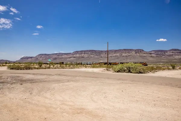 Image of mountains behind train through desert