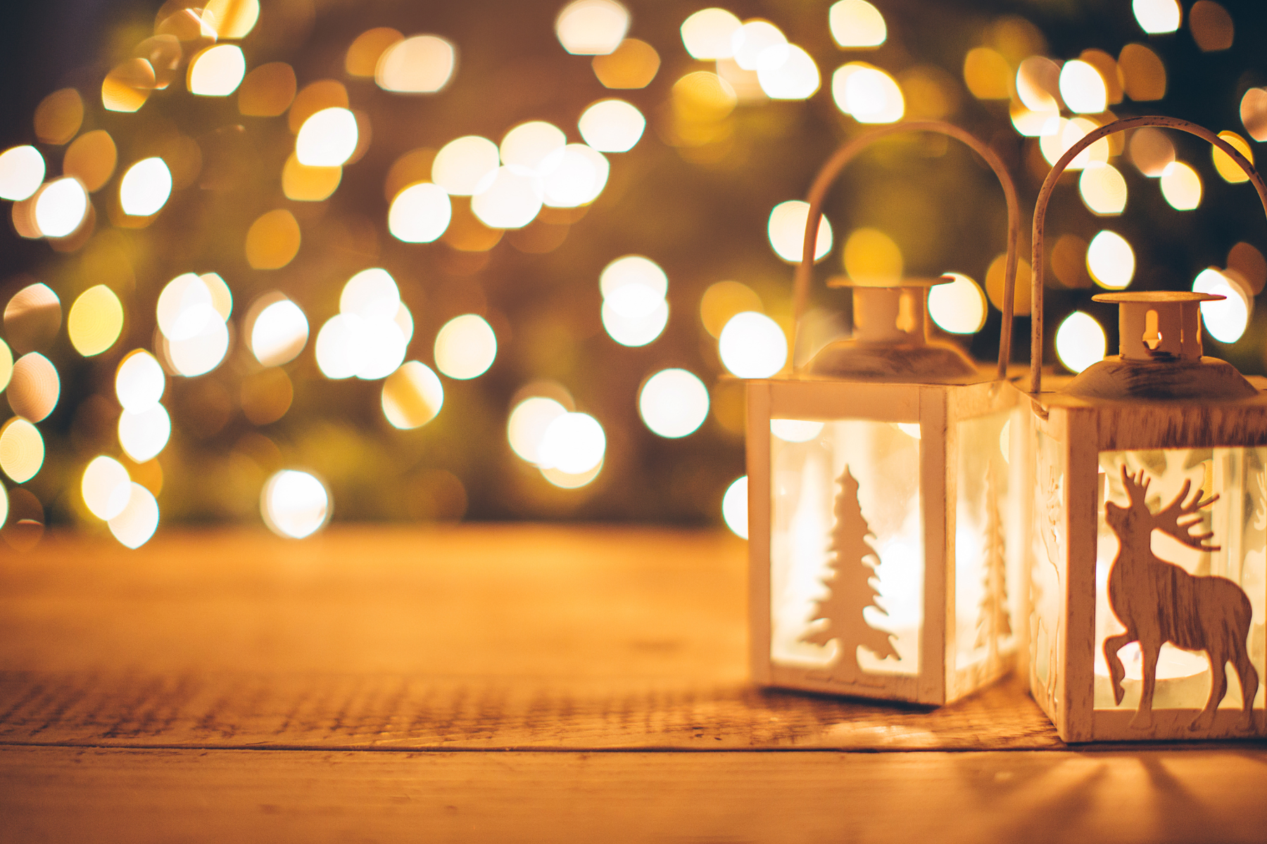 Festive lights with holiday candles on a wood table