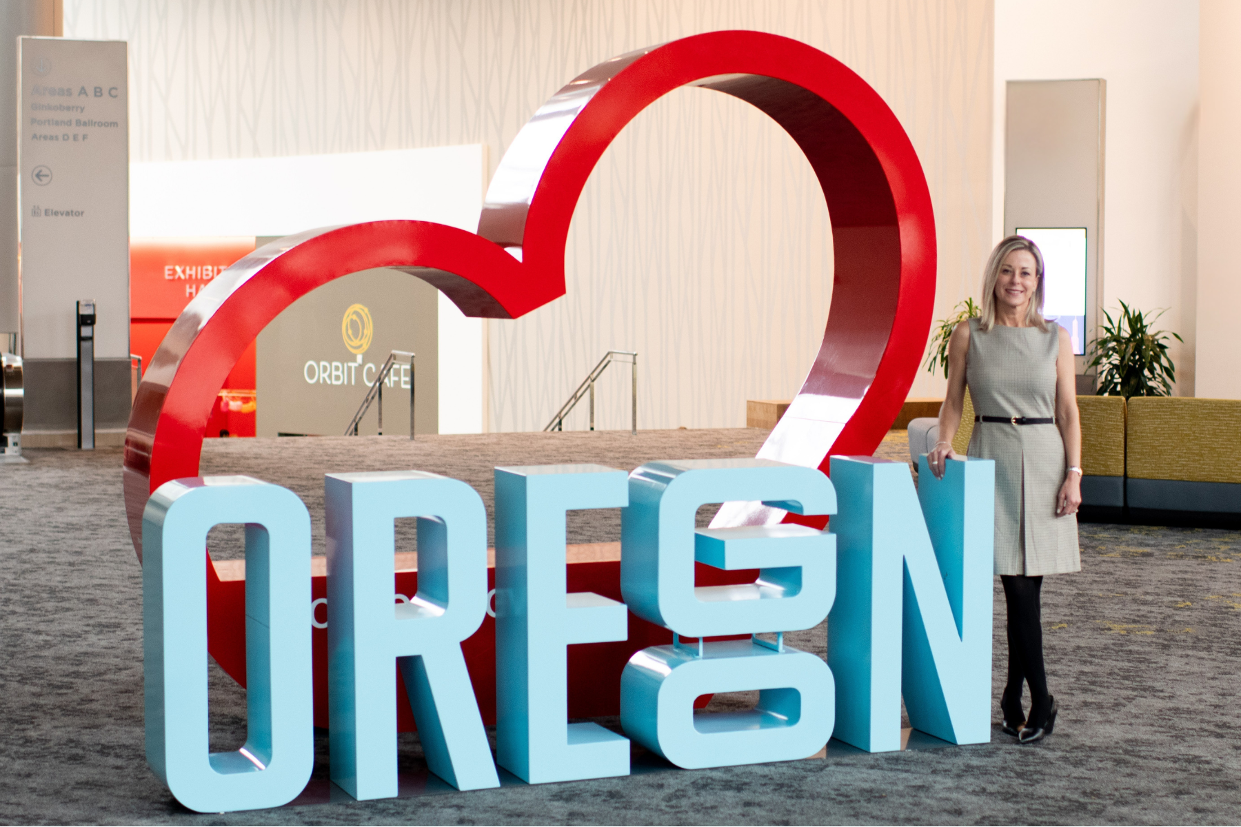 Cassidy Campanian standing next to a large Oregon sign